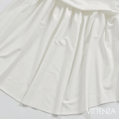 Close-up of the white Artemis Dress skirt, highlighting its flowing and gathered design.