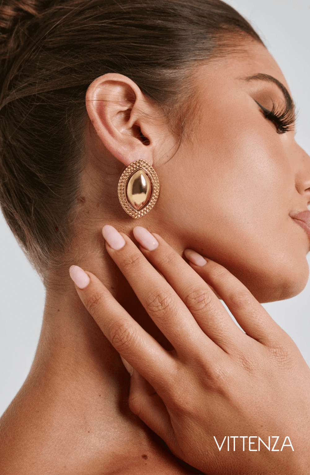 Close-up view of Azra Earrings in gold with a smooth metallic center and textured gold frame, highlighting the elegant design.