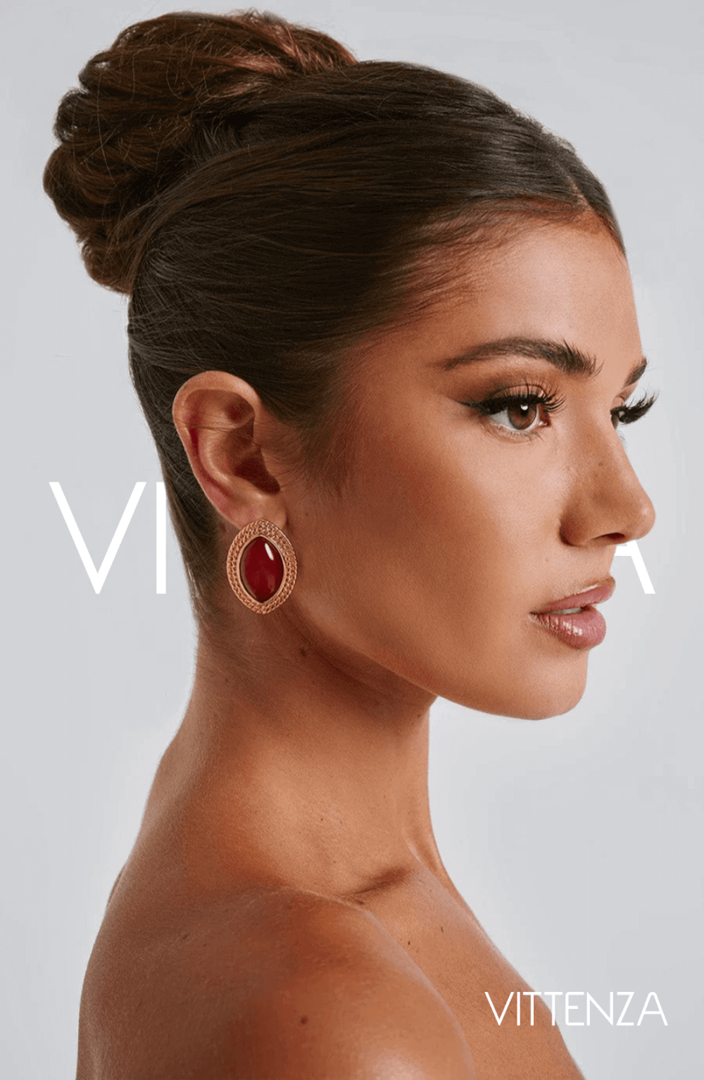 Side view of a model wearing Azra Earrings in red with a textured gold frame, showcasing the bold ellipse design.