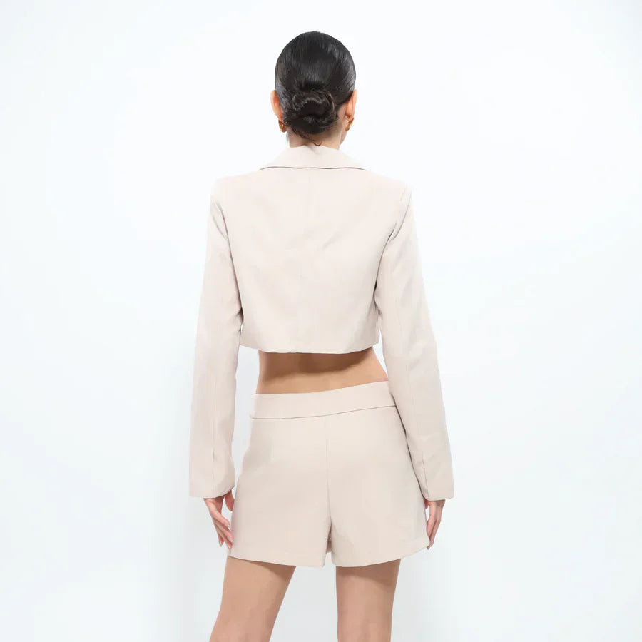 Back view of a beige cropped blazer and shorts set, showcasing the tailored fit.