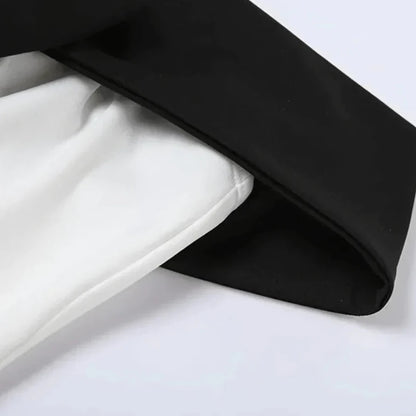 Close-up of the black and white fabric contrast on a classic off-shoulder dress.