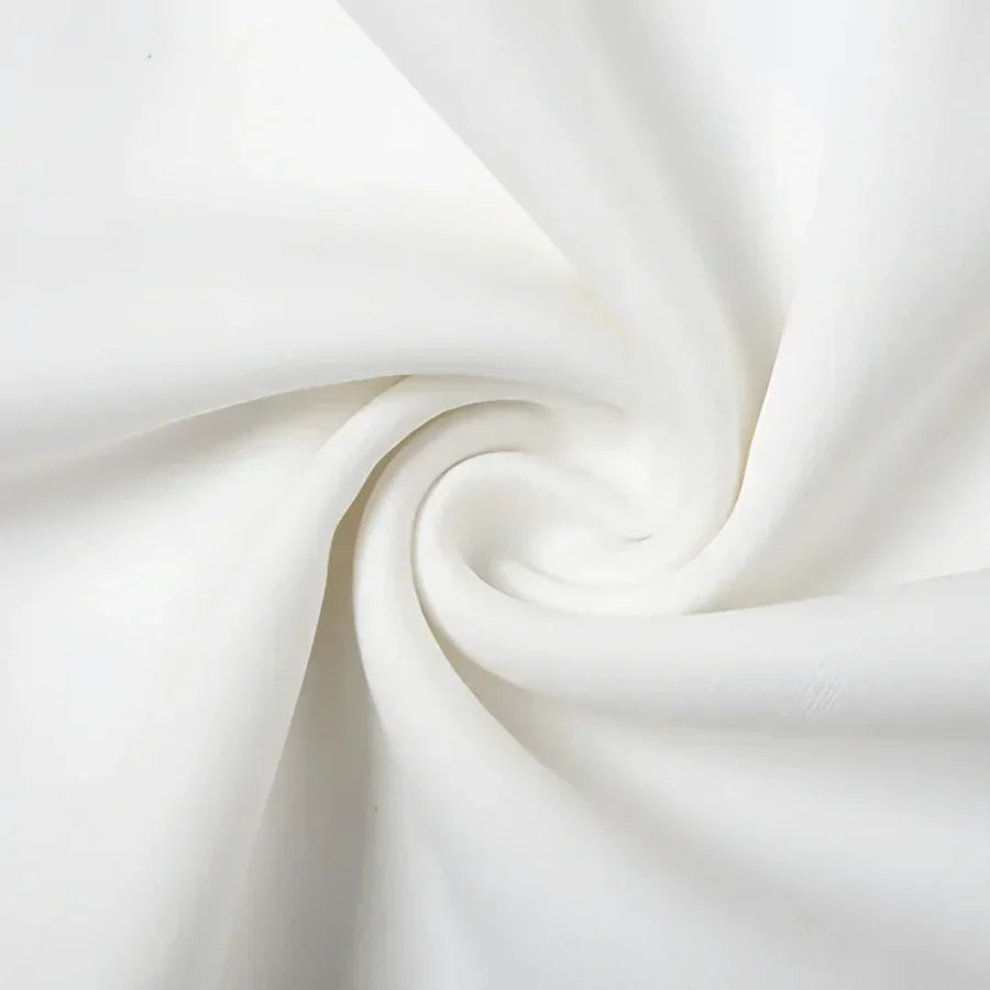 Close-up of the white fabric texture used in a classic off-shoulder dress.