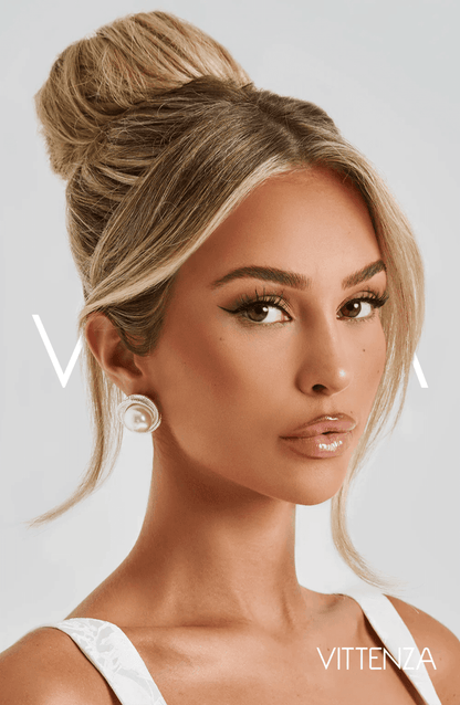 Close-up of a model wearing Davina Earrings in silver with a pearl centerpiece and textured frame, styled with a high bun.