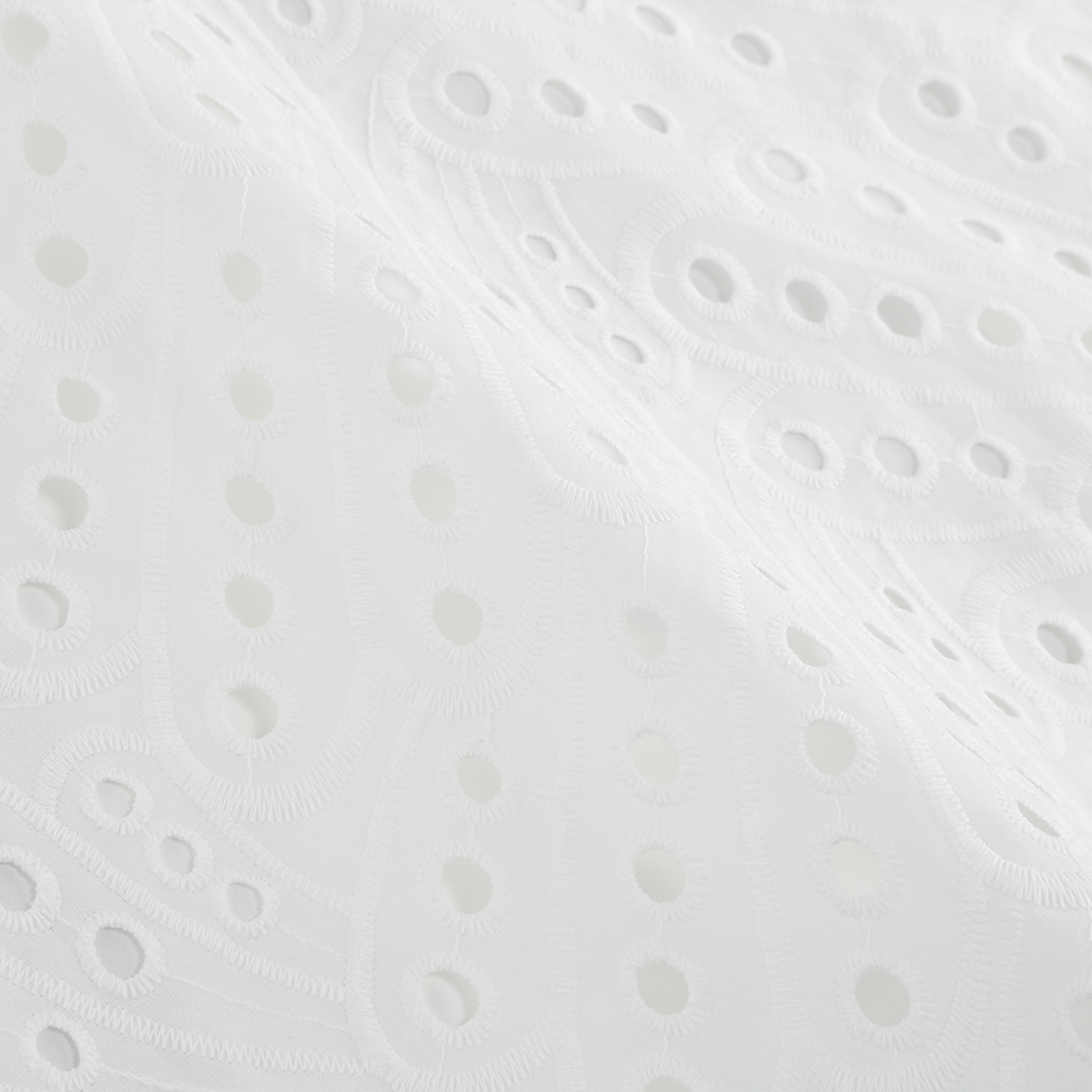 Close-up of the intricate embroidery pattern on the white Bali Dress fabric.