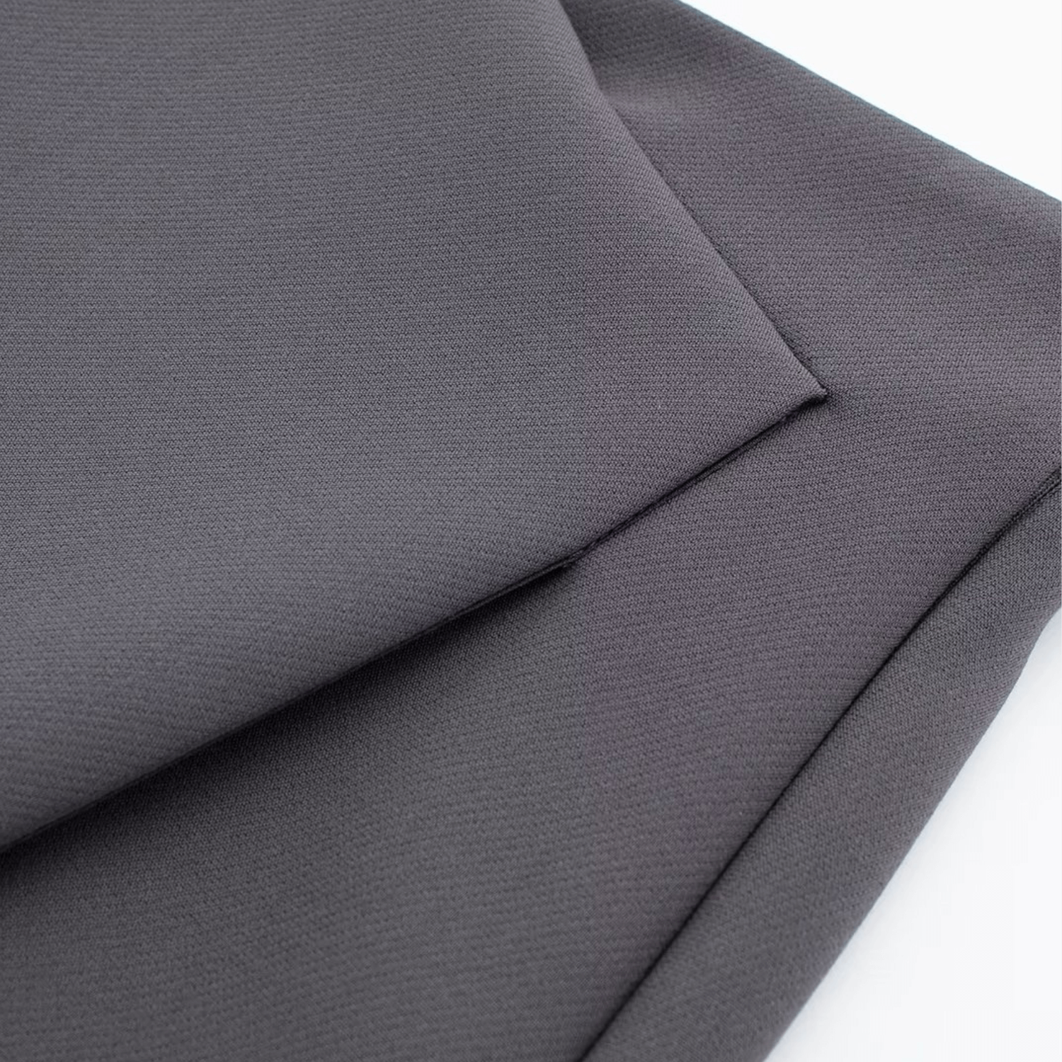 Close-up of the asymmetrical front design on the gray Barbie Shorts Skirt, highlighting its clean and modern aesthetic.