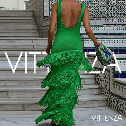 Back view of the green Bahamas dress worn by a model, showcasing the deep scoop neckline and layered fringe details.