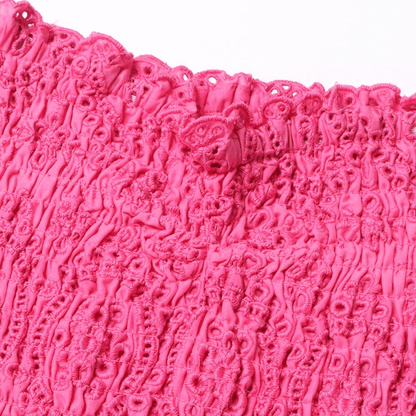 Close-up of the Gummy Dress's elastic strapless top with detailed pink embroidery.