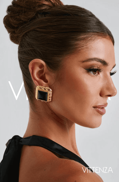 Side view of Kennedy Earrings in black and gold, showcasing the bold smooth stone center and textured gold frame.