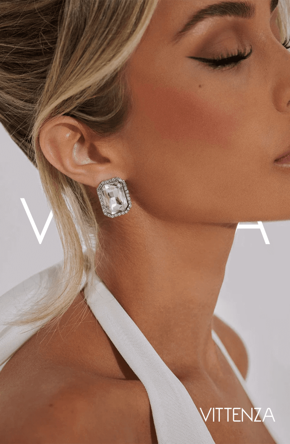 Side profile view of Odessa Earrings with a sparkling square rhinestone design, worn by a model in a white halter dress.