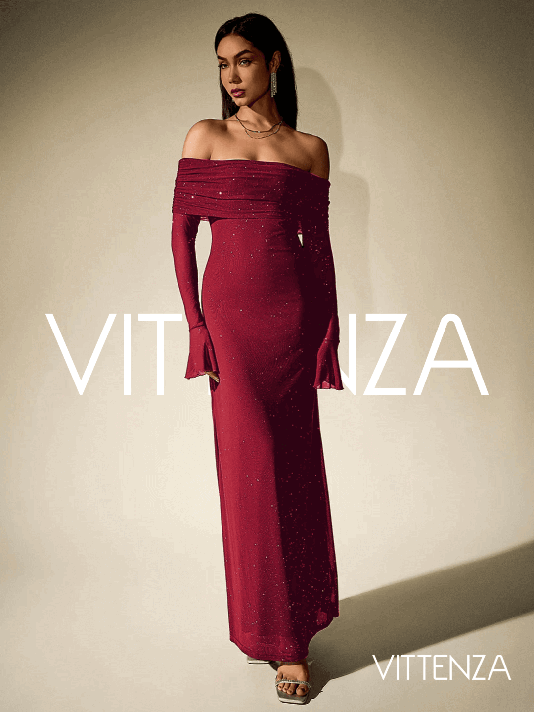 Angled front view of the Stellar Sparkle Maxi Dress in shimmering red, featuring its off-shoulder design, glittering details, and floor-length silhouette. The model accessorizes with statement earrings and metallic heels.