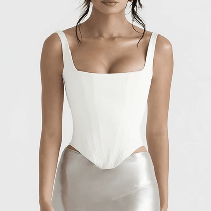 A front-facing view of a model wearing a white corset paired with a metallic silver skirt, showcasing its elegant and structured design.